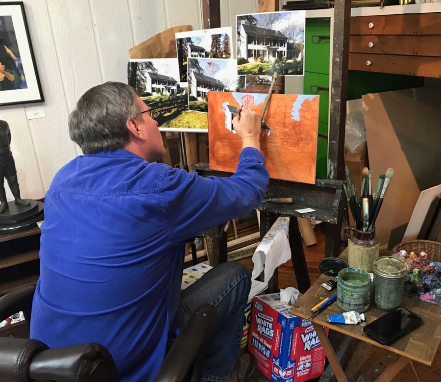 An artist painting a picture in his studio.